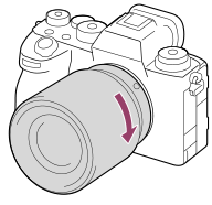 Ilustración que muestra cómo girar el objetivo hacia la derecha con la cámara orientada hacia usted