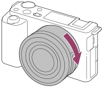 Illustratie die weergeeft hoe u de lens rechtsom draait met de camera naar u toe gekeerd