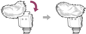 Illustration som visar hur man sätter på vindskyddet över mikrofonen från dess överdel