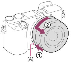 Illustration indicating the position of the lens release button and how to release the lens