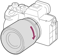 Illustration montrant comment tourner l’objectif dans le sens des aiguilles d’une montre avec l’appareil photo tourné vers vous