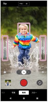 動画モードの撮影画面で、被写体の上のフォーカス枠、左側の色合いを調整するスライダー、右側の明るさを調整するスライダーを示した画面。