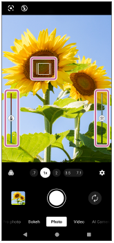 Image showing the focus frame on the upper left side, the color adjustment slider on the left side, and the brightness adjustment slider on the right side in the viewfinder of the [Photo] mode.