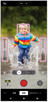 動画モードの撮影画面で、被写体の上のフォーカス枠、左側の色合いを調整するスライダー、右側の明るさを調整するスライダーを示した画面。
