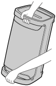 Illustration af højttaleren med det øverste og nederste håndtag grebet med begge hænder for transport